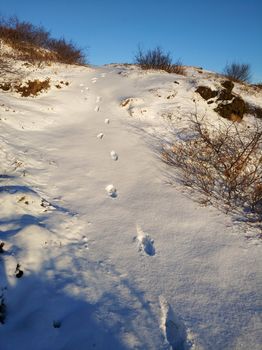 Human footprints in the snow. Up the mountain.