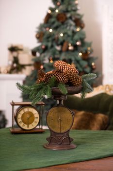 Stylish antique decor with pine cones. A handful of pine cones on an antique bronze scale.