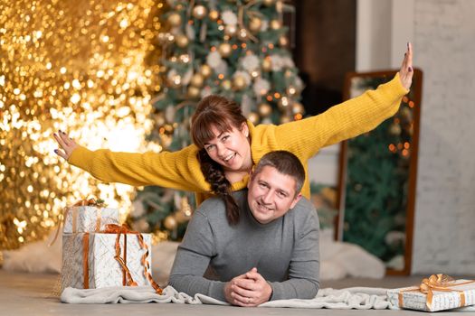 A beautiful cheerful couple greets the Christmas holidays in a cozy home atmosphere.