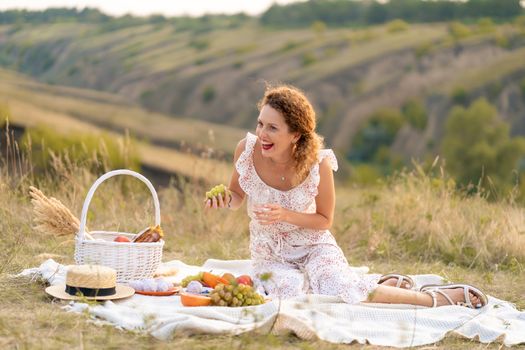 Beautiful girl on a picnic in a picturesque place. Romantic picnic.