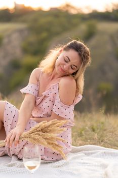 In the evening, the girl enjoys a picnic on a warm summer day