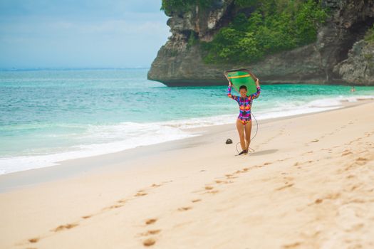 Sexy slim girl with surf board on tropical sand beach. Healthy active lifestyle in summer vocation