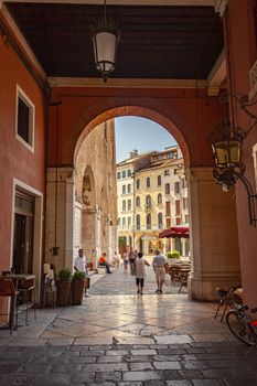 TREVISO, ITALY 13 AUGUST 2020: Arcades in Piazza dei signori in Treviso with people passing through