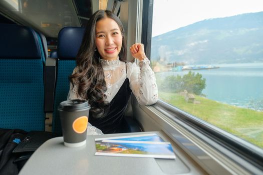 Young woman traveling looking view while sitting in the train.