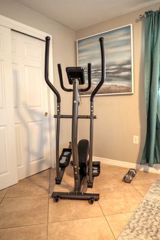 Elliptical machine in a home gym for home exercise and physical fitness.