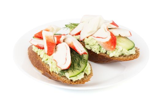 Crab sticks cut meat and vegetables avocado cucumbers sauce on rye bread sadswich on plate isolated on white background