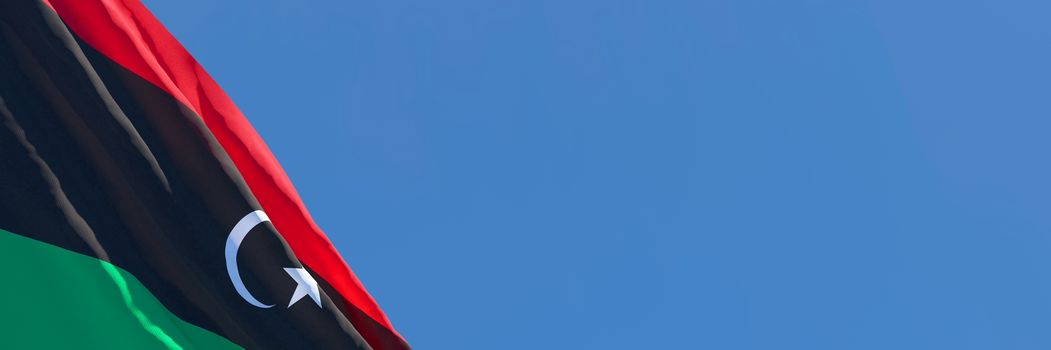 3D rendering of the national flag of Libya waving in the wind against a blue sky.