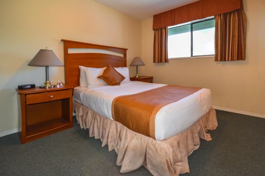 Interior of hotel bedroom with double bed and lamps on bedside tables