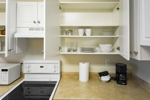 Open cabinets and primary appliances on average home kitchen