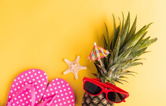 Celebrate Summer Pineapple Day Concept, Top view flat lay of funny fresh pineapple in sunglasses with starfish and slipper, in studio isolated on yellow background, Holiday summertime in tropical