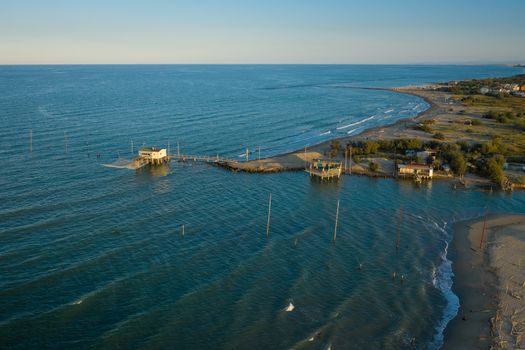 beautiful landscapes of the valleys near Ravenna (Fiumi Uniti) where the river flows into the sea with the typical fishermen's huts at sunset