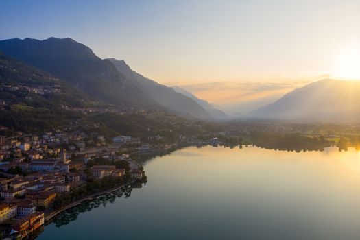 Drone view of Lake Iseo at sunrise, on the left the city of lovere which runs along the lake,Bergamo Italy.