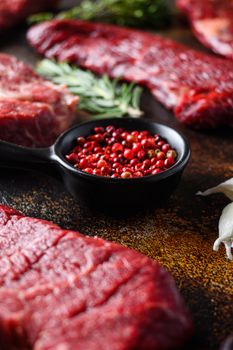 Side view Close up on red pepper near machete Steak, Flank steak, cut near denver alternative beef steak and a cleaver butcher meat knife a rustic metall background vertical.