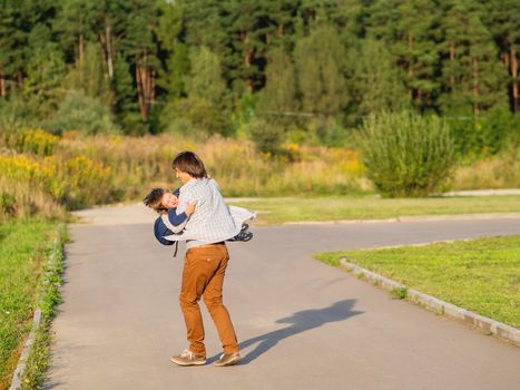 Father takes his son to school. Back to school after summer holidays. Dad and kid having fun on street. Emotional or moral support.