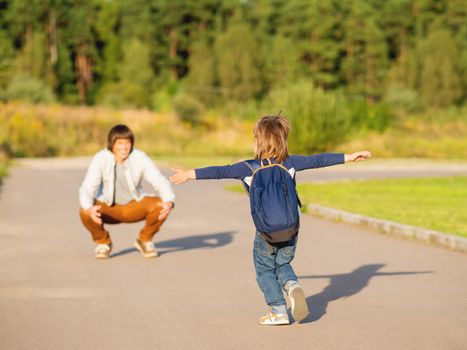 Father picks up his son from kindergarten. Back to school after summer holidays. Family time, moral support.