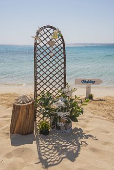 Closeup of wedding sign and decorations on tropical island sandy beach paradise with ocean in background