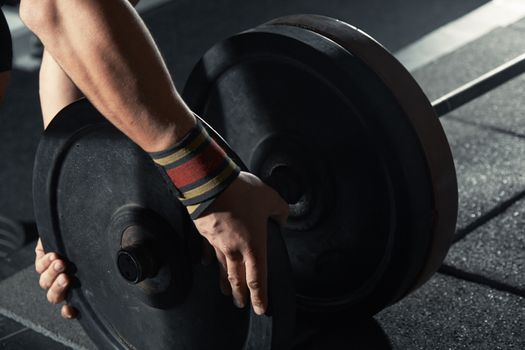 Man preparing barbell at fitness club