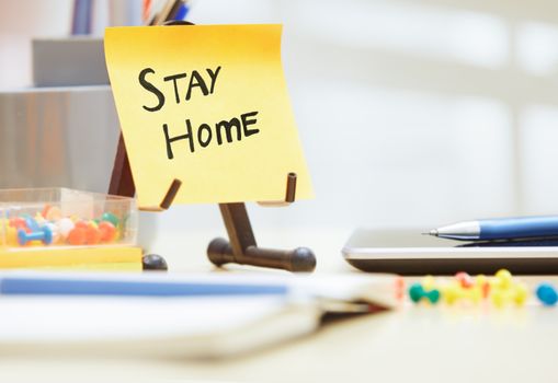 Stay Home text on adhesive note at the office