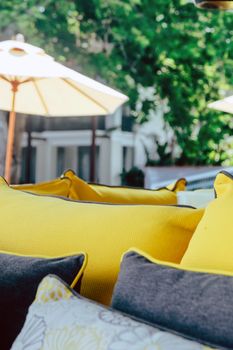 Close up of yellow fabric sofa and cushions decorate in tropical resort