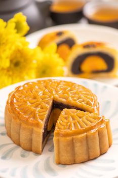 Tasty baked egg yolk pastry moon cake for Mid-Autumn Festival on bright cement table background. Chinese traditional food concept, close up, copy space.