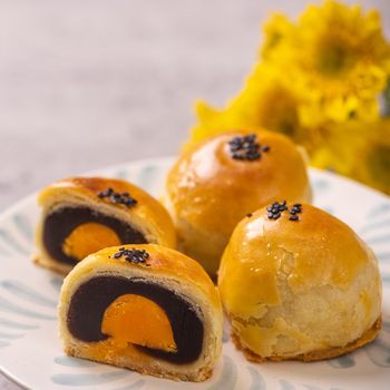 Tasty baked egg yolk pastry moon cake for Mid-Autumn Festival on bright cement table background. Chinese traditional food concept, close up, copy space.