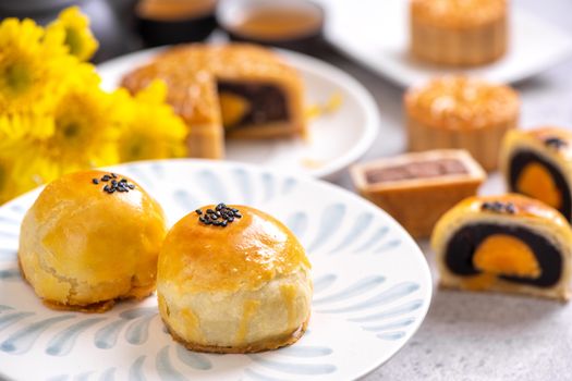 Tasty baked egg yolk pastry moon cake for Mid-Autumn Festival on bright cement table background. Chinese traditional food concept, close up, copy space.