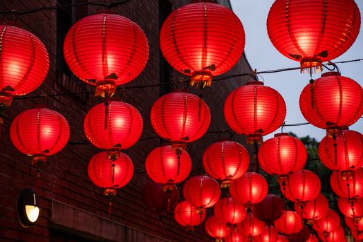 Beautiful round red lantern hanging on old traditional street, concept of Chinese lunar new year festival in Taiwan, close up. The undering word means blessing.