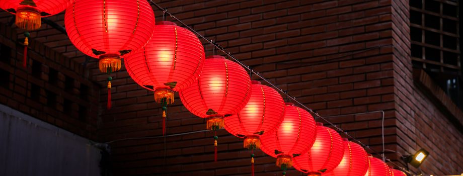 Beautiful round red lantern hanging on old traditional street, concept of Chinese lunar new year festival in Taiwan, close up. The undering word means blessing.