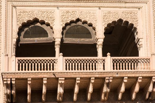 Exterior view of an ornately carved window and balcony on an old temple in Vrindavan, a holy town in Mathura, Uttar Pradesh, India, Asia.