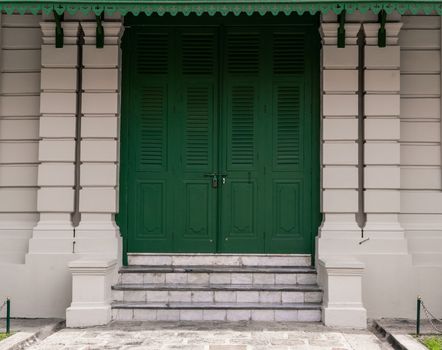 Green door with brick for background