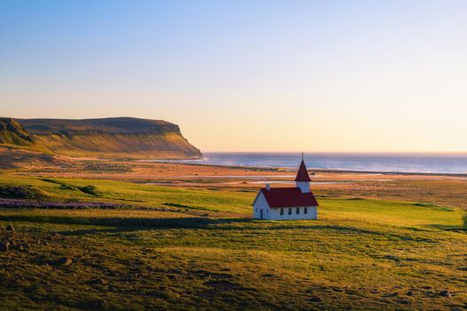 Sunset at the Breidavik church located at the sand beach in Westfjords, Iceland