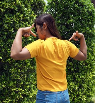 Asian woman Wearing a yellow shirt With a finger pointing at the back of himself.