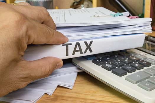 Hand of Man search and hold Tax Files folder at office 
