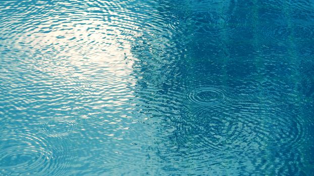 Rain drop on the surface of swiming pool water and have a ripple wave effect texture. 