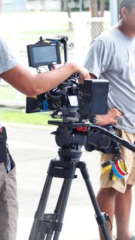 Behind the scenes of movie or video shooting production camera set and film crew at outdoor location.