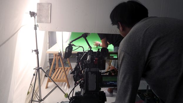 Behind the TV commercial video online shooting scenes and production people are working in silhouette.
