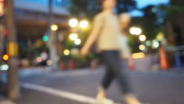 Blurry image of city street life in evening of Osaka Japan and colorful bokeh effect lights.