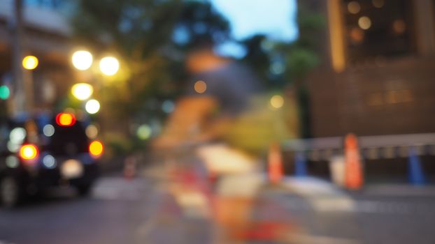 Blurry image of city street life in evening of Osaka Japan and colorful bokeh effect lights.