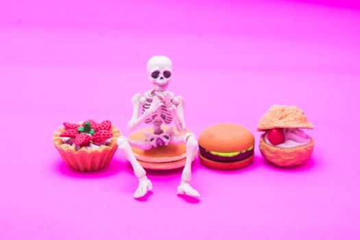 Skeleton sitting on bakery, enjoy eating until death with sweet desserts.
