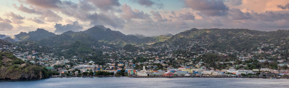 Amazing aerial panoramic landscape shot of St. Vincent island in the Caribbean Sea. Beautiful sunset clouds and mountains in the background. High angle shot.