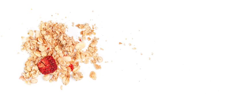 Muesli flakes with one dried strawberry, closeup photo isolated on white background space for text right side.