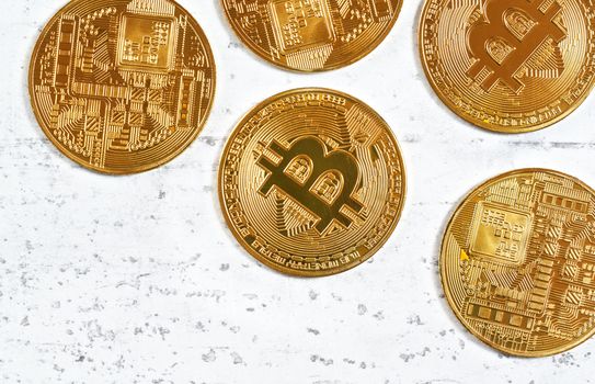 Top down view, golden commemorative btc - bitcoin cryptocurrency - coins scattered on white stone board, closeup detail, empty space down left corner.