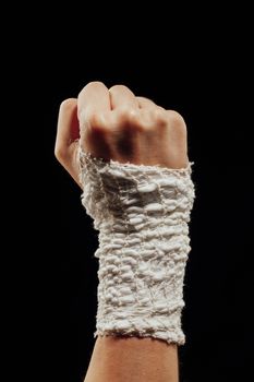 wrist wrapped with healing bandage, isolated on black