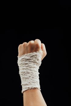 wrist wrapped with healing bandage, isolated on black