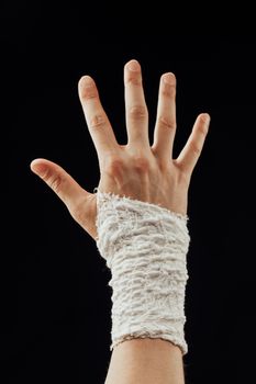 wrist wrapped with healing bandage, isolated on black