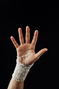 wrist wrapped with healing bandage, isolated on black