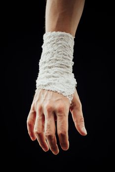 wrist wrapped with healing bandage, isolated on black