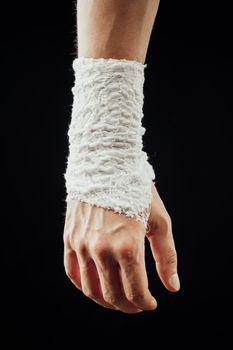 wrist wrapped with healing bandage, isolated on black