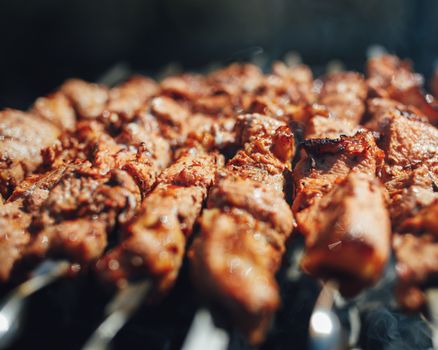 grilled barbecue meat on skewers with smoke