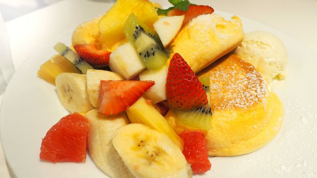 Japanese pancake and many kind of fruits include banana strawberry kiwi orange and serve with ice-cream.